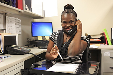 Teen with a Cognitive Disorder talking on phone in an office