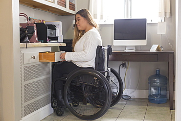 Woman with Spinal Cord Injury arranging things in her room