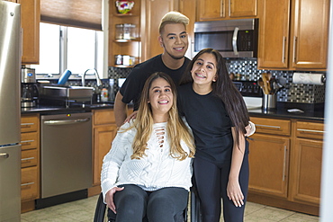 Woman who has Spinal Cord Injury standing with her friends in the kitchen