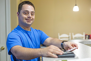 Man with Down Syndrome holding a credit card