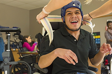 Boy with Spastic Quadriplegic Cerebral Palsy using using his helmet and strap