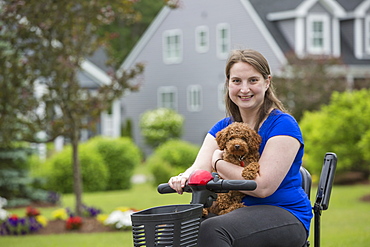 Young Woman with Cerebral Palsy riding the scooter with her dog