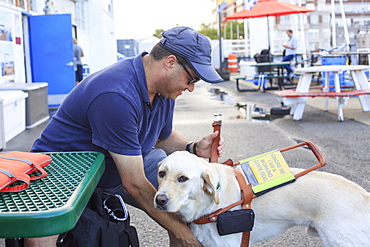 Blind man sitting with his service dog