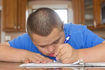 Teen with Down Syndrome studying