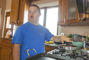 Teen boy with Down Syndrome cooking