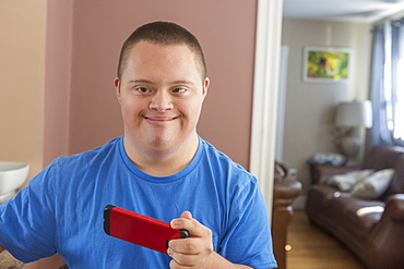 Teen with Down Syndrome holding his phone