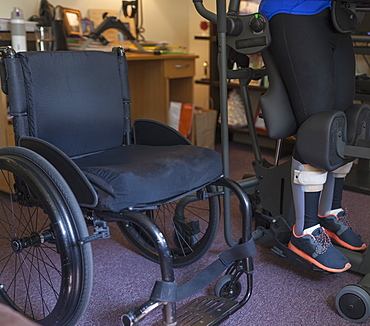 Woman with spinal cord injury getting into her desk so she can stand up