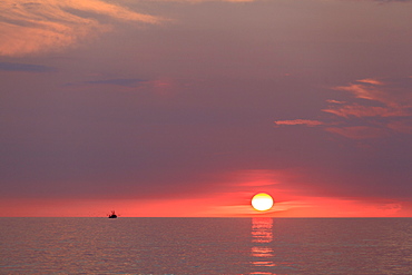 Sunrise over ocean on Block Island with fishing trawler, Rhode Island, USA