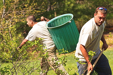 Landscapers raking and removing weeds