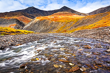 Kuyuktuvuk Creek and Brooks Mountains in fall colours. Gates of the Arctic National Park and Preserve, Arctic Alaska in autumn; Alaska, United States of America