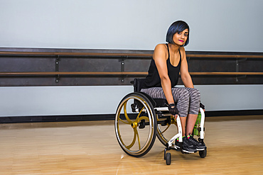 A paraplegic woman taking a break in a gymnasium after working out in a recreational facility: Sherwood Park, Alberta, Canada