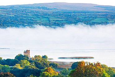 Castlebawn Tower house on the banks of Lough Derg surrounded in fog on an autumn morning; Clare, Ireland