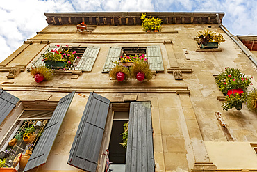 House with shutters and floral hanging baskets; Arles, Provence, France