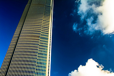 Architectural detail of a skyscraper with blue sky and white clouds; Hong Kong, Hong Kong Special Administrative Region (SAR), Hong Kong