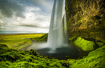 View of a rushing waterfall taken from behind, Seljalandsfoss; Iceland