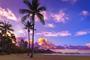 Sunrise over Waikiki with glowing clouds and an empty beach; Waikiki, Oahu, Hawaii, United States of America