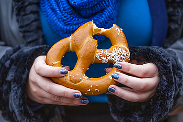 Woman eating a pretzel; New York City, New York, United States of America