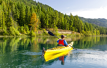 A teenage boy kayaking on White Lake, White Lake Provincial Park; British Columbia, Canada