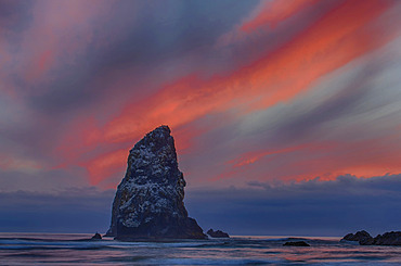 Dramatic sunset light in clouds over beach and rock formations on the Oregon coast; Cannon Beach, Oregon, United States of America