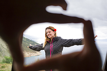 Framing a beautiful girl with fingertips with the Croatian coastline in the background; Pisak, Splitsko-dalmatinska zupanija, Croatia