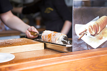 Fresh Chimney cakes are prepared during a summer festival that takes place in the German city of Dresden; Dresden, Sachsen, Germany