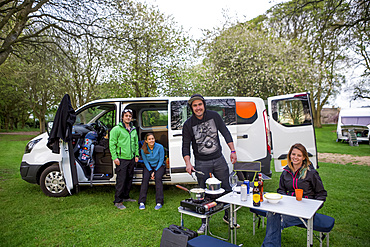 Setting up camp outside of a modified caravan camper; Bourton-on-the-Water,  Gloucestershire, England