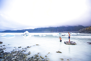 Men swimming in the icy glacial lakes of Mount Cook National Park; Canterbury, New Zealand