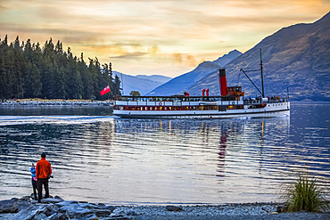 Tourists watching the famous TSS Earnslaw takes a sunset tour around Queenstown's Lake Wakatipu; Otago, New Zealand