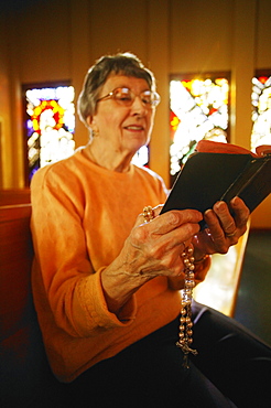 Woman Reading Bible & Holding Rosary Beads