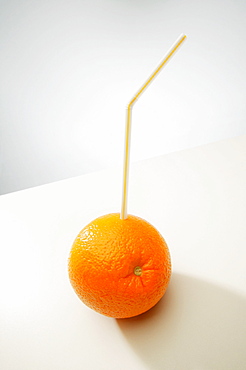 An Orange With A Straw