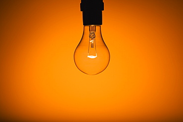 Light Bulb On Orange Glowing Background