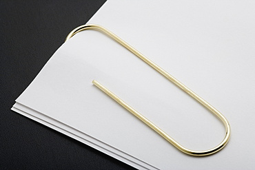 White Paper Clipped With Gold Paper Clip