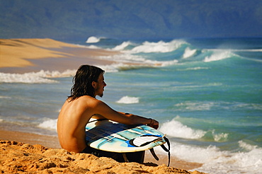 Surfer Sitting On The Beach