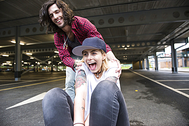 A cool young couple having fun with a skateboard.