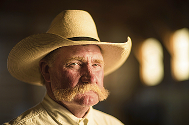 Portrait of a rancher wearing a cowboy hat in a barn, Burwell, Nebraska, United States of America