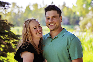 Outdoor portrait of a husband and wife in a city park during a warm fall afternoon, Leduc, Alberta, Canada