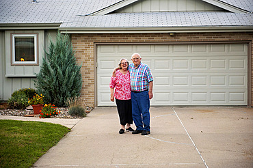 Elderly couple pose together outside their home, Elkhorn, Nebraska, United States of America