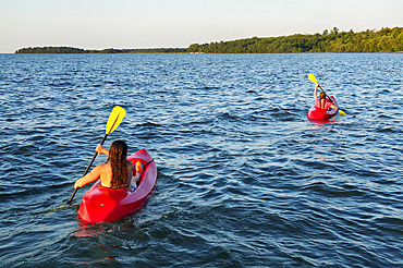 Teenage girl kayaking with a friend on Leech Lake in Minnesota, USA, Walker, Minnesota, United States of America