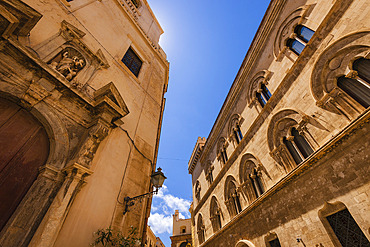 View looking up at the ornate stone work of the old buildings in the historic, Old Town of Trapani, Trapani, Sicily, Italy