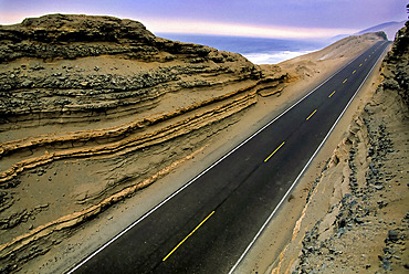 The Pan American Highway is an empty, lonely, desolate road as it runs along Peru's Pacific Desert Coast along the ocean for hundreds of miles, Near Chala, Peru