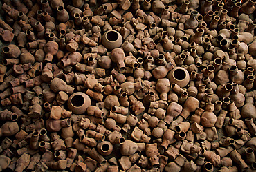 Clay pots piled on a tomb of the Lord of Sipan archeological site near Chiclayo, Peru in the Lambayeque Valley. Archaeologists uncovered burial places of several lesser important figures besides royalty at Sipan. One, a high priest, had a tomb almost as impressive as the royal ones. Another burial contained 1,137 pots shaped into warriors, priests, prisoners, musicians, and anthropomorphic deities, Sipan, Peru