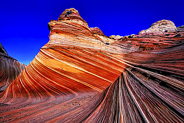 Spectacular formation of vibrant colors in swirls of fragile sandstone is known as The Wave and is located in the Coyote Buttes section of Vermilion Cliffs National Monument. An unmarked wilderness trail limits hikers and requires a permit from the Bureau of Land Management, Arizona, United States of America