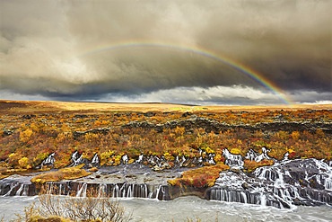 Hraunfossar Falls and a rainbow in the sky under storm clouds, near Reykholt, in west Iceland, Iceland