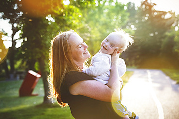 Outdoor portrait of a mother spending quality time with her son who has Down Syndrome in a city park during an bright sunny autumn day, Leduc, Alberta, Canada