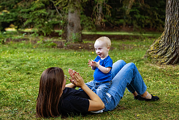 Older sister spending quality time with her young brother who has Down Syndrome, in a city park during a warm fall afternoon, Leduc, Alberta, Canada