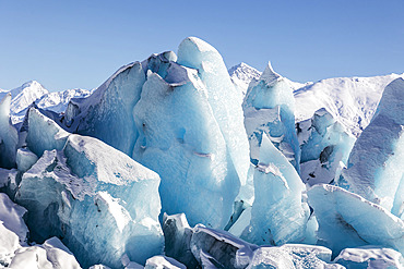 Blue ice formations on Knik glacier against a bright blue sky, Alaska, United States of America