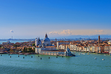 View from the Church of San Giorgio Maggiore of the City of Venice with Chiesa Santa Maria della Salute at Punta della Dogana and boats traveling through the Grand Canal on a sunny day, Venice, Veneto, Italy