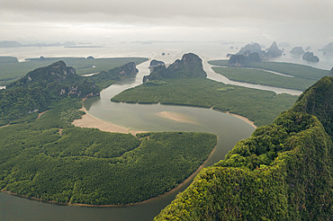 Expanse of lush vegetation, tranquil waterways and rock formations under a cloudy sky viewed from the drone in Thailand, Ao Phang Nga, Phang-nga, Thailand