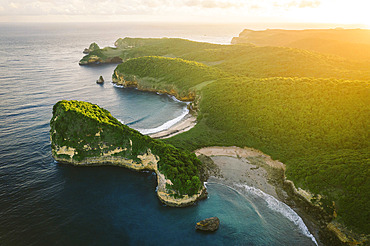 Lush vegetation and coastline in golden sunset light at Sari Goang Beach Lagoon in Indonesia, Mertak, Pujut, Central Lombok Regency, West Nusa Tenggara, Indonesia