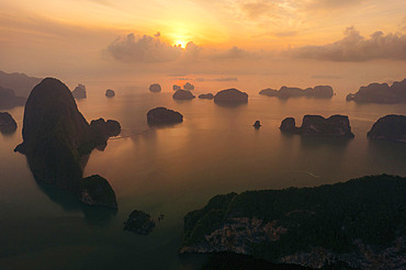 Karst rock formations and a dramatic sunrise in Ao Phang Nga National Park, with mist over the Southern Thailand landscape, Ao Phang Nga, Phang-nga, Thailand